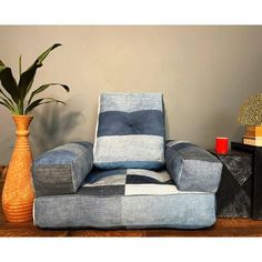 a blue and white chair next to a vase with a plant