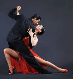 a man and woman dance together in an artistic pose with their arms around each other