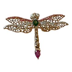 This delicate and lovely openwork Dragonfly brooch/pin is clearly inspired by the era of Art Nouveau. Made in warm 18 K rose Gold it is featuring an oval vivid green Tsavorite weighing 0.37 ct, 1 pear shape pink Sapphire weighing 0.52 ct, 76 round pink Sapphires weighing 0.27 ct, 147 brillinat cut Diamonds weiging 0.48 ct amd 2 cultured freshwater Pearls. In almost every part of the world, the dragonfly symbolizes change, transformation and new beginnings. It has the ability to change both physi Dragonfly Brooch, K Rose, Dragonfly Jewelry, Freshwater Cultured Pearls, Make A Wish, Pink Sapphire, Estate Jewelry, Pear Shaped, Or Rose