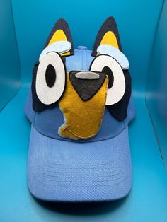 a blue hat with an animal face on it's front and back side, sitting on a blue chair