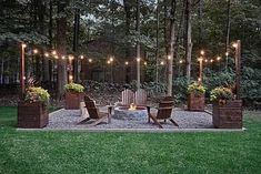 an outdoor fire pit surrounded by potted plants and lights in the middle of a yard