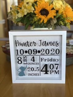 a white frame with a baby's birth date and sunflowers in the background