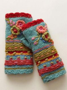 two colorful knitted mittens sitting on top of each other