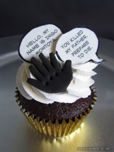 a cupcake with white frosting and black icing