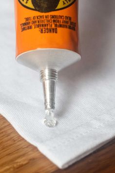 an orange cup sitting on top of a white napkin next to a small plastic bottle