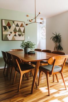 a dining room table with chairs and a potted plant