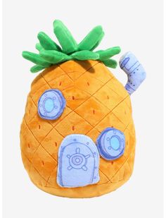 a stuffed pineapple with blue eyes and green leaves on it's head, sitting in front of a white background