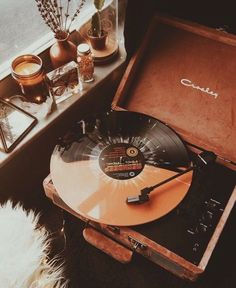 an old record player sitting on top of a suitcase