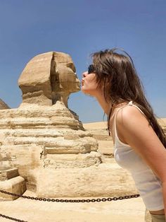 a woman standing in front of the sphinx at giza, with her mouth open