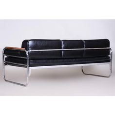 a black leather couch with chrome legs on a white background