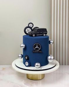 a blue and white cake with a mercedes truck on top