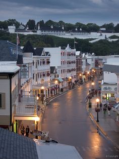 a city street at night with people walking on the sidewalks