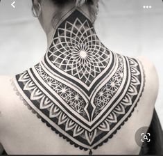 the back of a woman's neck with an intricate design on it