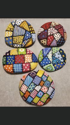 four colorfully painted rocks sitting on top of a table