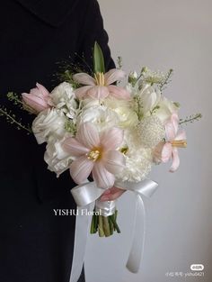 a woman holding a bouquet of white and pink flowers