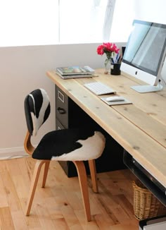 a desk with a computer, keyboard and mouse on it in front of a window