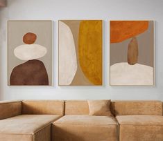 three abstract paintings hang on the wall above a couch in a living room with beige furniture