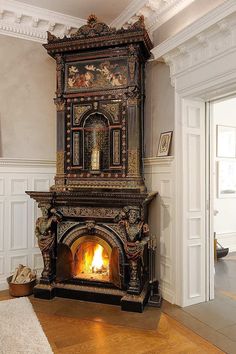 an ornate fireplace in the middle of a room with wood flooring and white walls