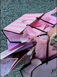 a person is holding some pink paper bags