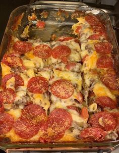 a pizza casserole with pepperoni and cheese in a glass dish on the stove