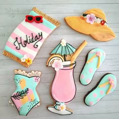 decorated cookies are arranged in the shape of flip flops, sunhat, and umbrella