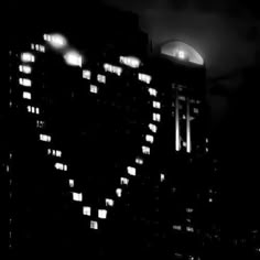 black and white photograph of heart shaped building at night