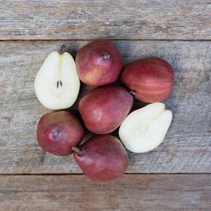 apples and pears are arranged on a wooden surface