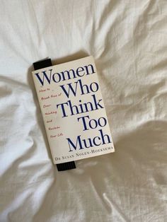 the book women who think too much is laying on top of a white bed sheet