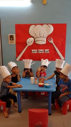 children sitting at a table with chefs hats on