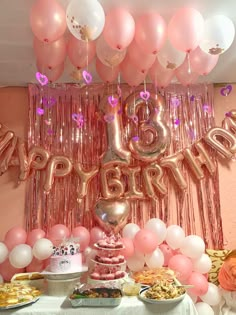 a pink and white birthday party with balloons, cake and desserts on the table