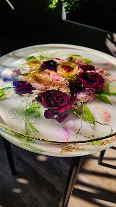 a glass plate with flowers on it sitting on a table