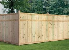 a large wooden fence in the grass