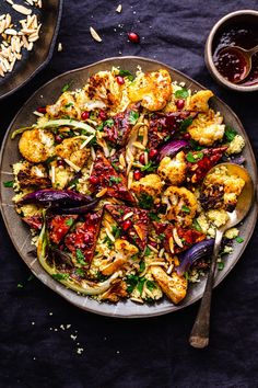 a plate filled with shrimp and vegetables on top of a table next to bowls of sauce