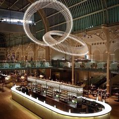 the interior of a restaurant with circular chandeliers hanging from the ceiling