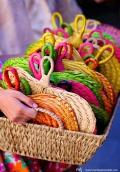 a person holding a basket filled with lots of colorful items