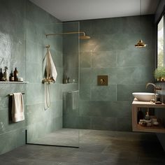 a bathroom with green walls and tile flooring, including a walk - in shower