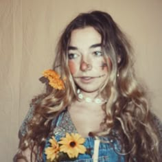 a woman with long hair and sunflowers in her hair is posing for the camera