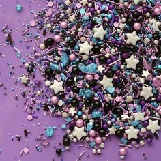 purple and blue confetti sprinkles on a purple background with stars