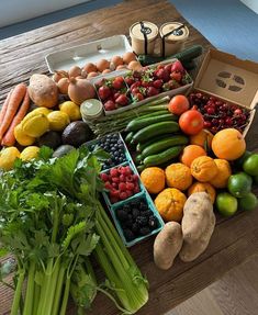 a wooden table topped with lots of fresh fruits and veggies on top of it