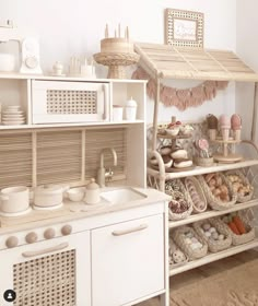 a kitchen filled with white appliances and lots of dishes on top of wooden shelves in front of a window