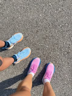 two people standing next to each other with their feet up in the air on asphalt