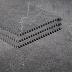 three pieces of black marble sitting next to each other on top of a gray floor