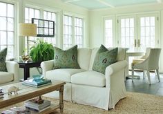 a living room filled with furniture and lots of windows