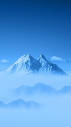 the mountains are covered in thick fog under a blue sky