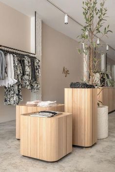 two wooden stools sitting next to each other in front of a mirror and clothes rack