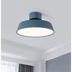 a blue ceiling light hanging from the ceiling in a room with white walls and curtains