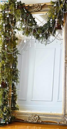 a mirror decorated with christmas garland and ornaments