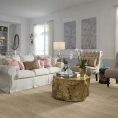 a living room with white furniture and wood flooring in it's center area