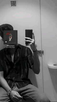 a man taking a selfie in front of a bathroom mirror with his cell phone