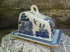 a blue and white porcelain covered dish on a doily